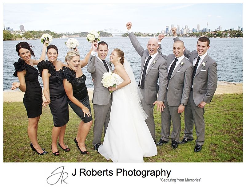 Bridal party cheering with Sydney Harbour in the background - wedding photography sydney